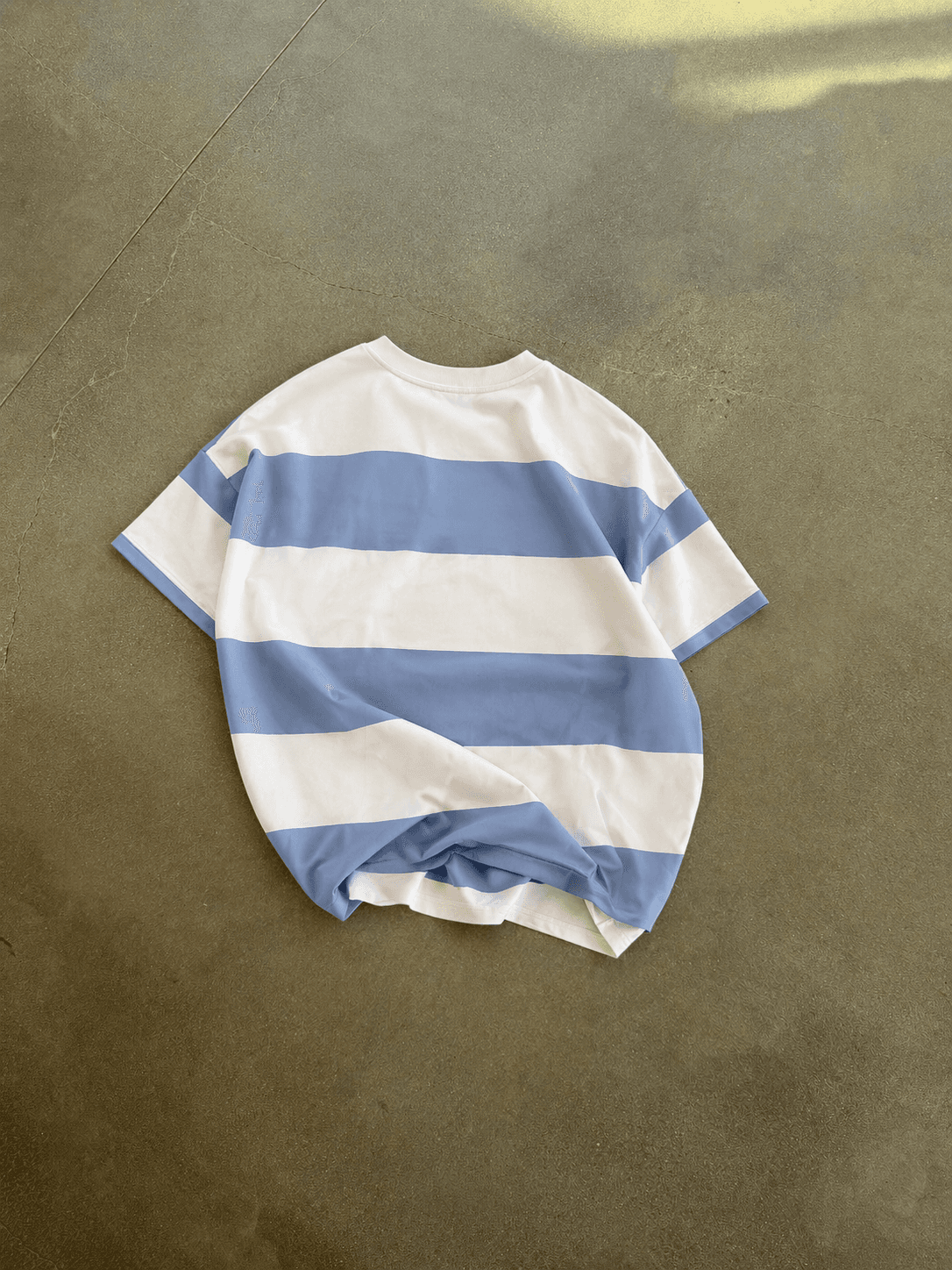 Blue and white striped t-shirt on a brown surface