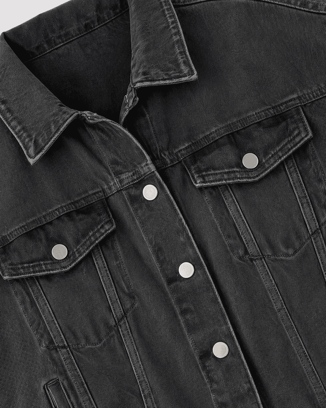 Close-up of a black denim jacket with button details